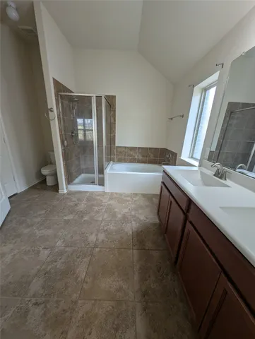 an empty room with wooden floor chandelier fan and windows