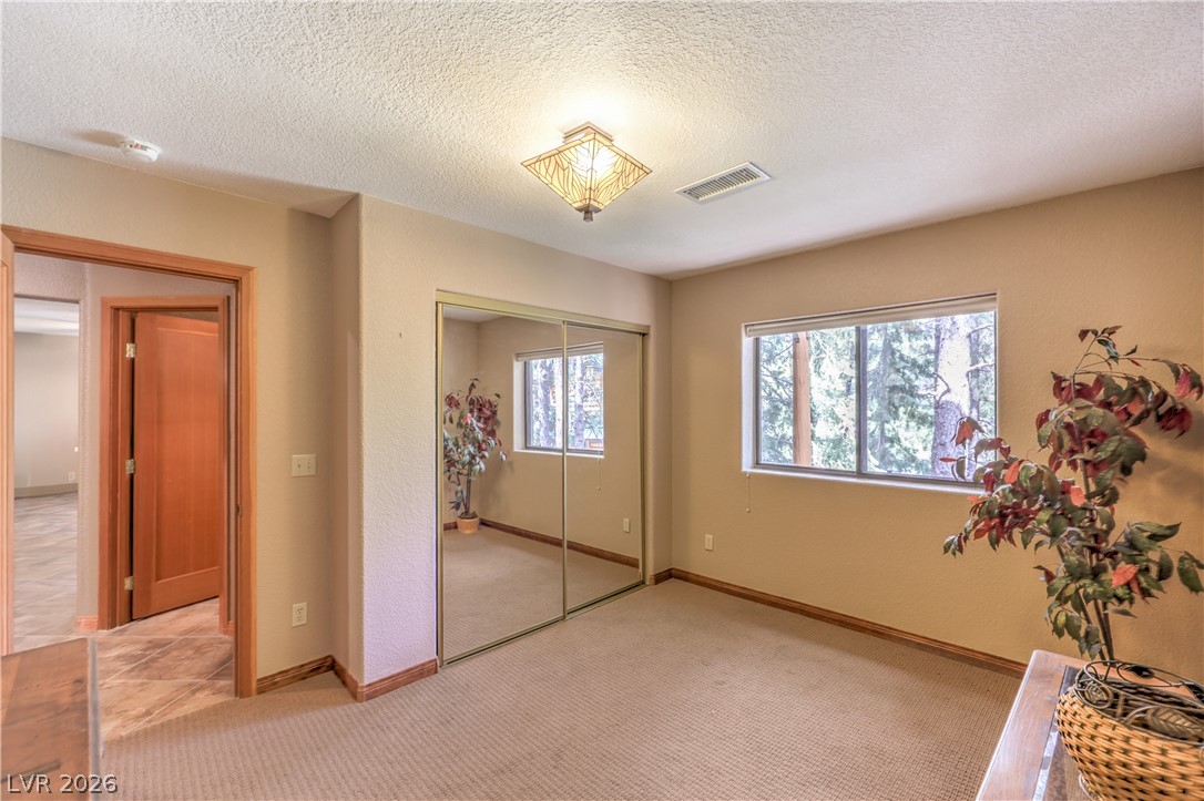 322 Ski Trail Road Mount Charleston, NV 89124 - Photo 28 of 58 Natural light streams through the window of this bedroom featuring mirrored closet doors.
