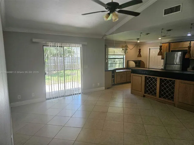 a large kitchen with a large counter top space a sink a window and stainless steel appliances