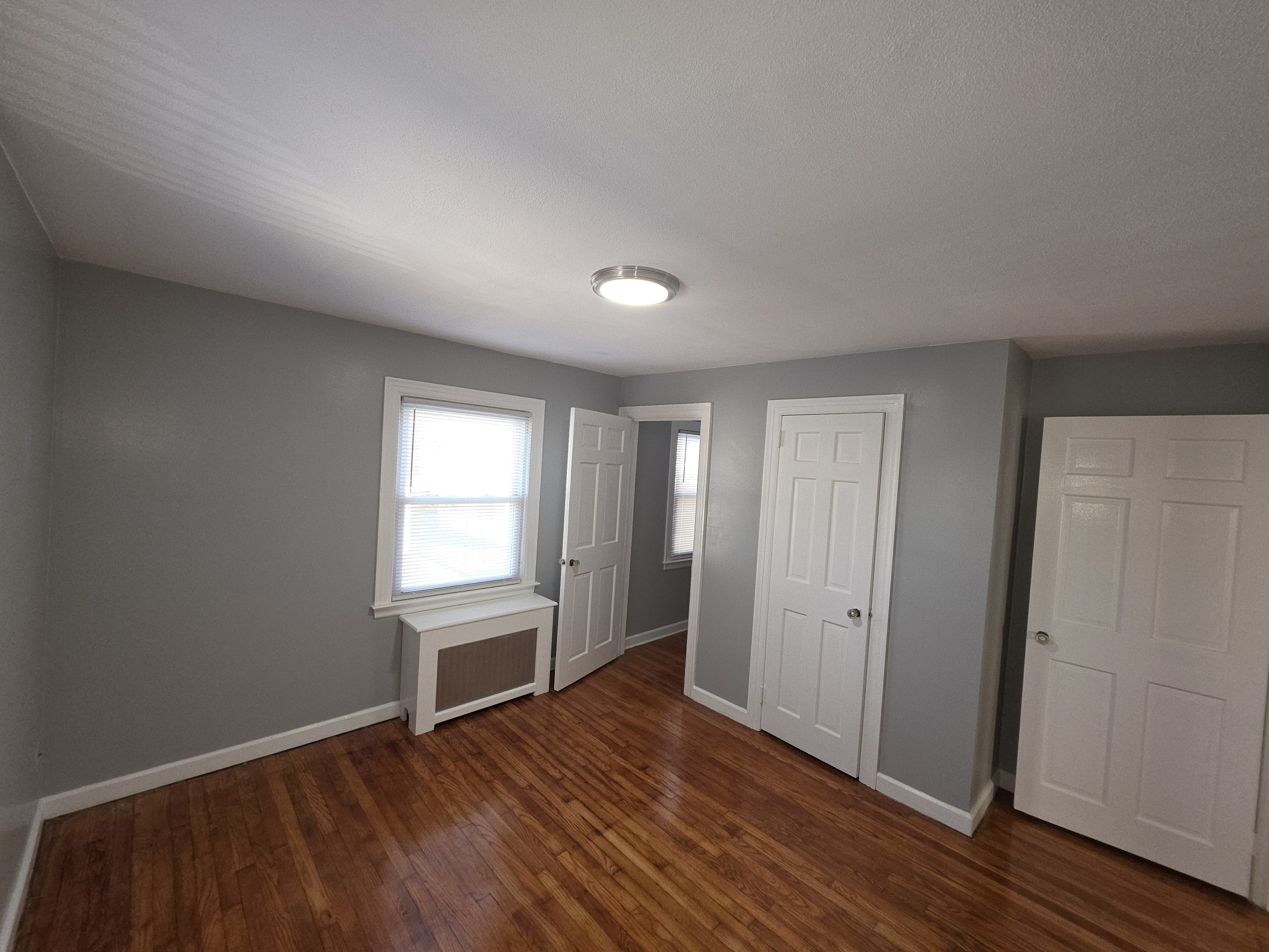 15 Keller Avenue Enfield, CT 06082 - Photo 11 of 13 an empty room with wooden floor and windows