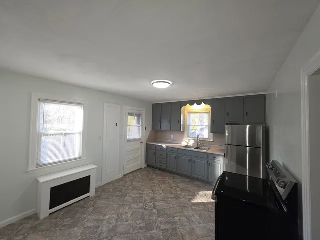 a kitchen with granite countertop white cabinets and stainless steel appliances