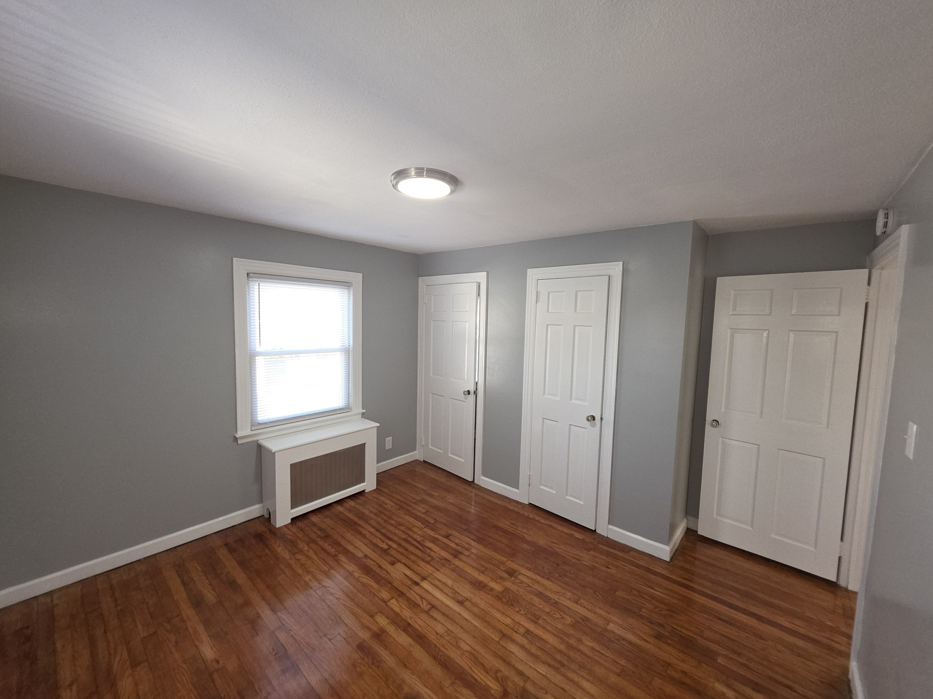 15 Keller Avenue Enfield, CT 06082 - Photo 10 of 13 an empty room with wooden floor and windows