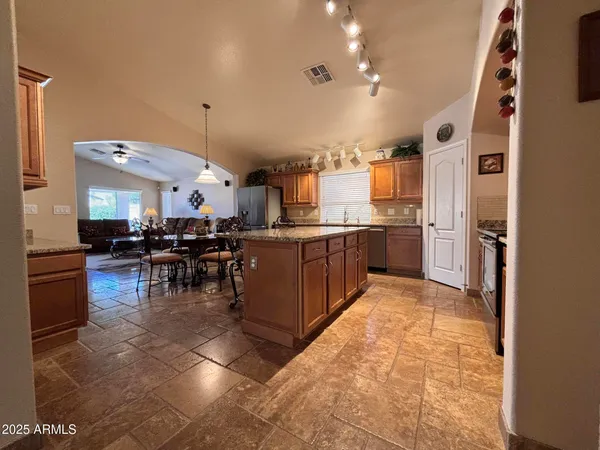 a kitchen with stainless steel appliances kitchen island granite countertop a sink and cabinets