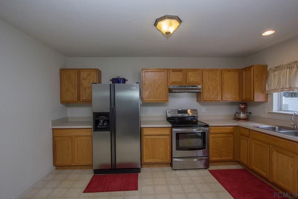 3 Riddle Place Palm Coast, FL 32164 - Photo 14 of 47 a kitchen with a sink stainless steel appliances and cabinets