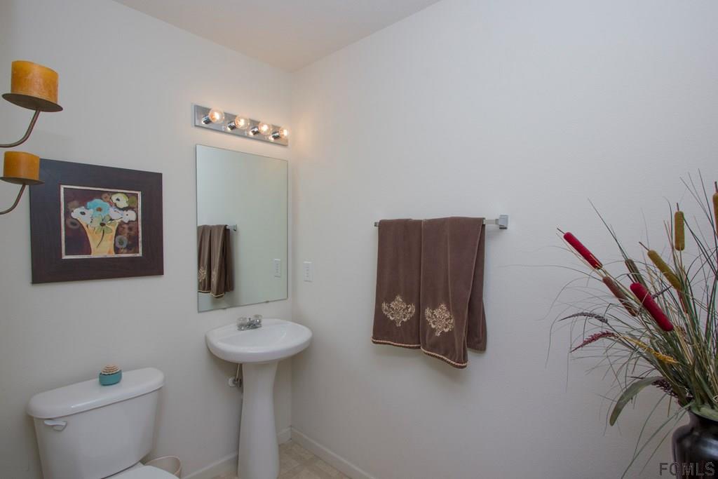 3 Riddle Place Palm Coast, FL 32164 - Photo 16 of 47 a bathroom with a toilet sink and mirror
