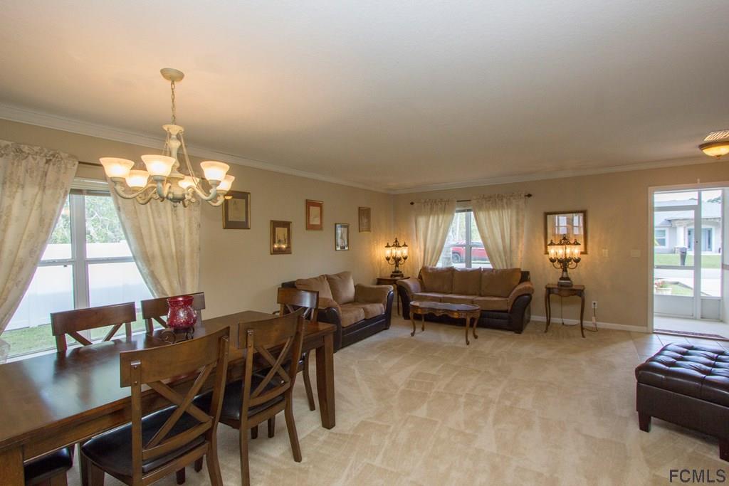 3 Riddle Place Palm Coast, FL 32164 - Photo 3 of 47 a living room with furniture and a chandelier