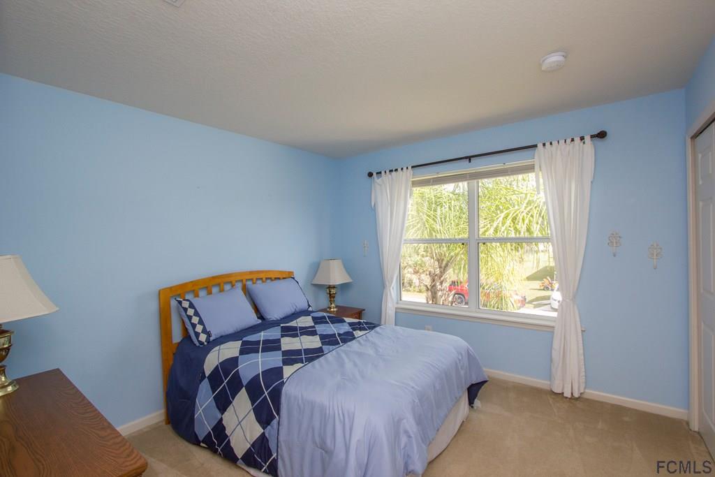 3 Riddle Place Palm Coast, FL 32164 - Photo 21 of 47 a bed sitting in a bedroom next to a window