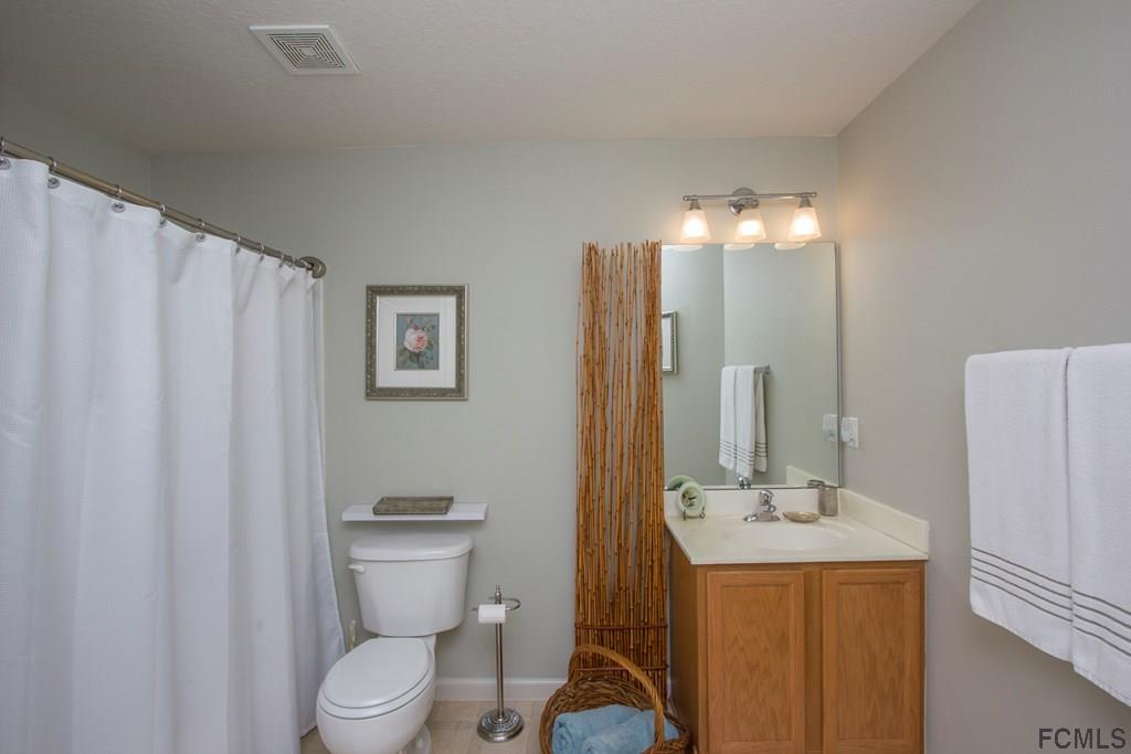 3 Riddle Place Palm Coast, FL 32164 - Photo 24 of 47 a bathroom with a toilet a sink and a mirror