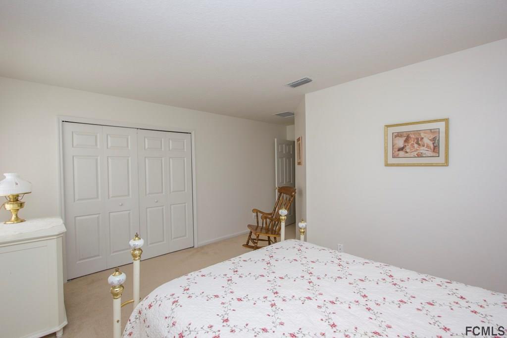 3 Riddle Place Palm Coast, FL 32164 - Photo 30 of 47 a bedroom with a bed and a table in it