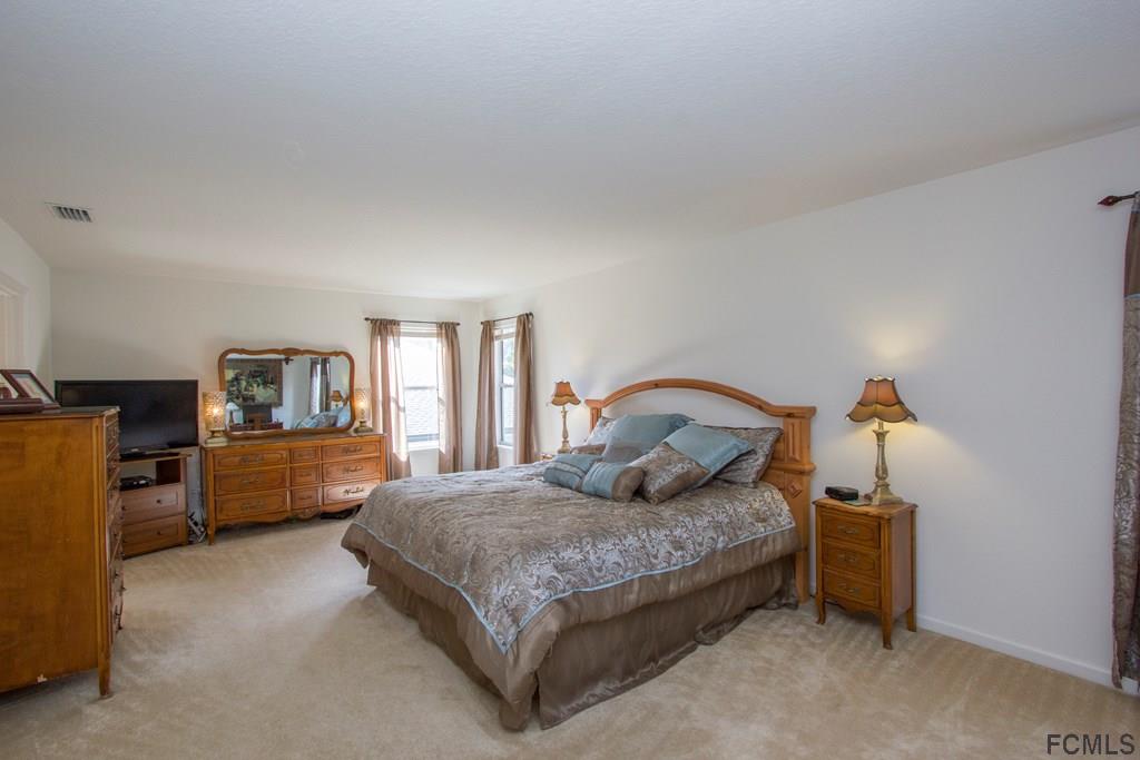 3 Riddle Place Palm Coast, FL 32164 - Photo 31 of 47 a bedroom with a bed and a dresser
