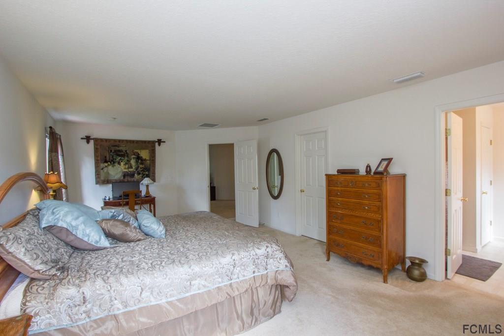 3 Riddle Place Palm Coast, FL 32164 - Photo 34 of 47 a bedroom with a bed and a cabinets