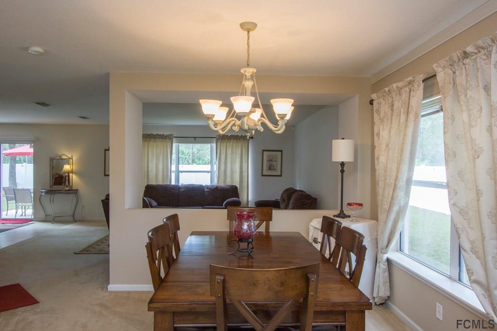 3 Riddle Place Palm Coast, FL 32164 - Photo 5 of 47 a view of a dining room with furniture and a chandelier
