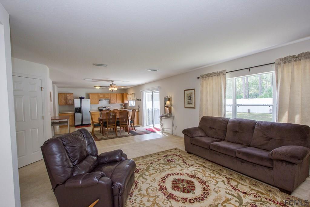 3 Riddle Place Palm Coast, FL 32164 - Photo 8 of 47 a living room with furniture and a large window