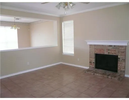 a view of an empty room with window and fire place