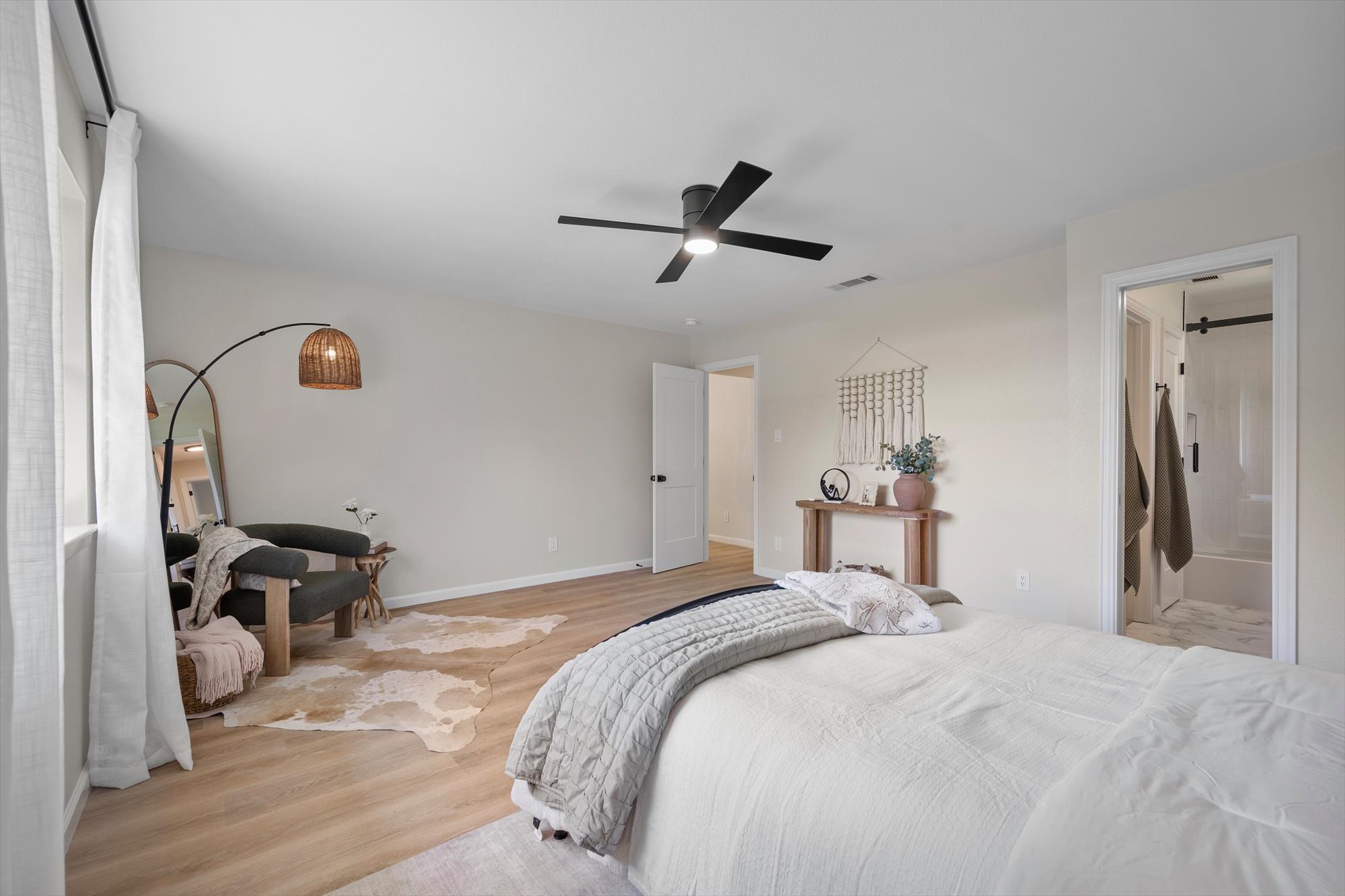 109 Woodland Road Georgetown, TX 78628 - Photo 24 of 40 A tranquil primary bedroom with light wood flooring and a modern ceiling fan, offering a serene retreat.