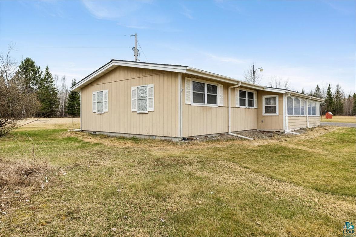 11574 Town Line Road Hibbing, MN 55746 - Photo 26 of 41 Single-story residence featuring light-toned vertical siding, multiple windows with white shutters, a dark shingled roof, and a screened-in porch