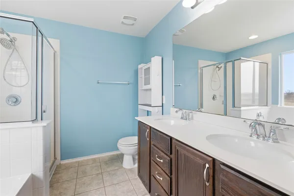 a bathroom with a double vanity sink mirror and toilet