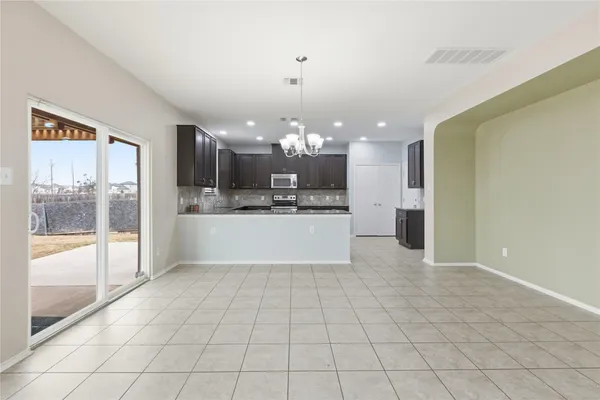 a large white kitchen with a large window cabinets and stainless steel appliances