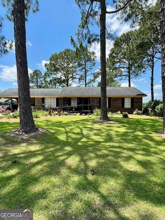 a view of a house with swimming pool and a large tree
