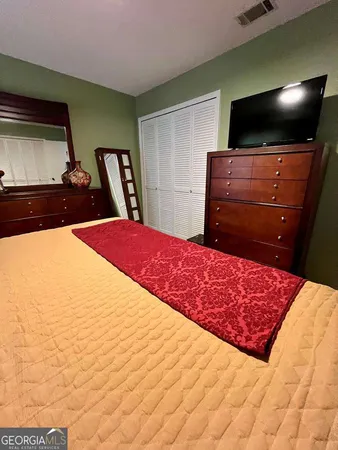 a bedroom with a bed and flat screen tv