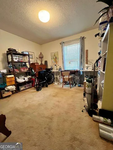 a living room with furniture gym equipment and a large window