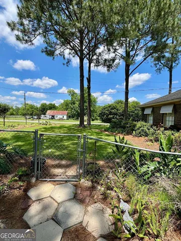 a view of a garden with a tree in front of the house