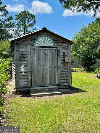 a view of a small house with wooden fence