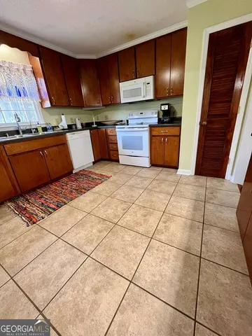 a kitchen with stainless steel appliances kitchen island granite countertop a refrigerator stove and sink