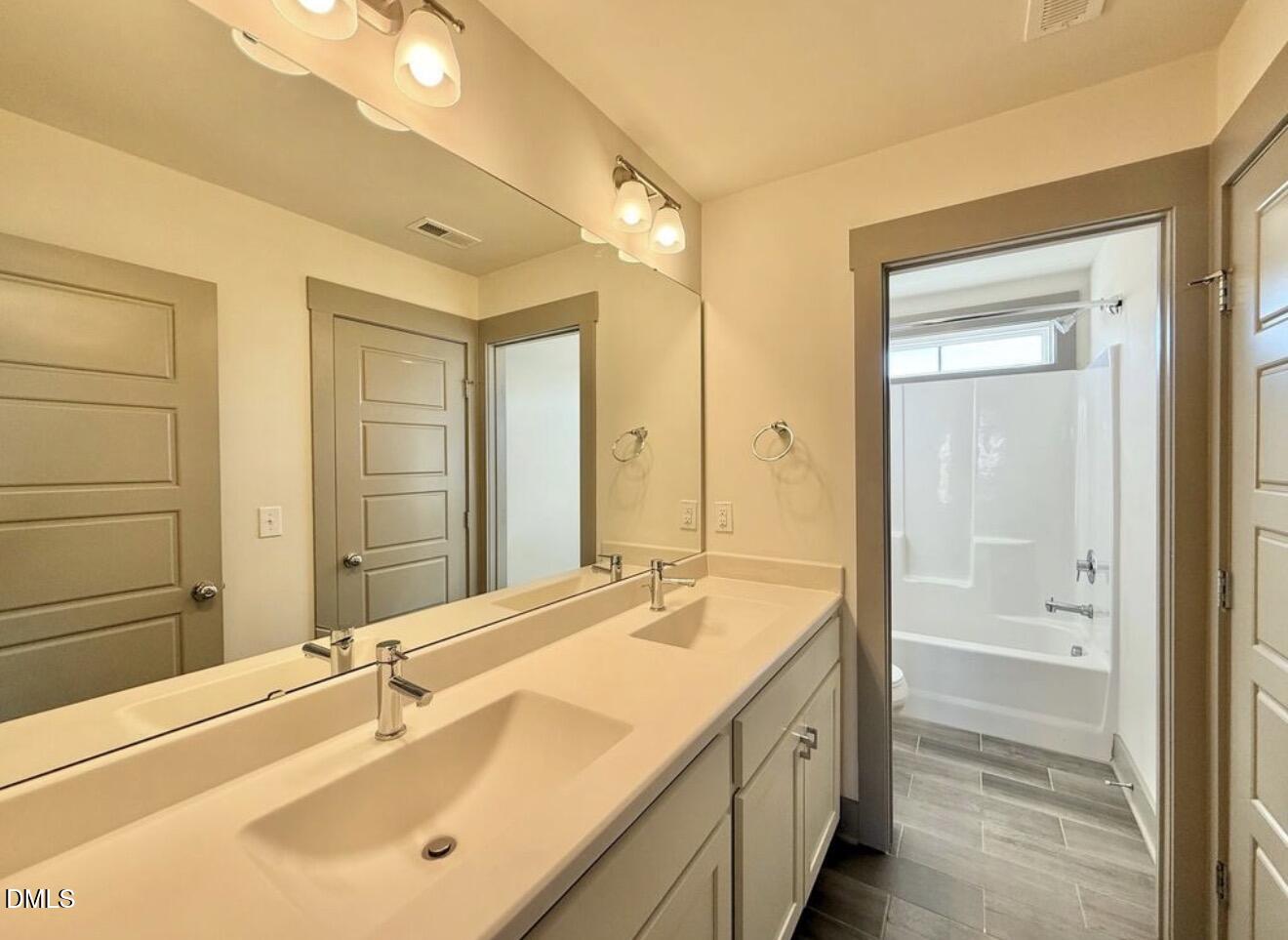1529 Rhodeschool Drive Wendell, NC 27591 - Photo 20 of 36 a bathroom with a double vanity sink a mirror and a bathtub