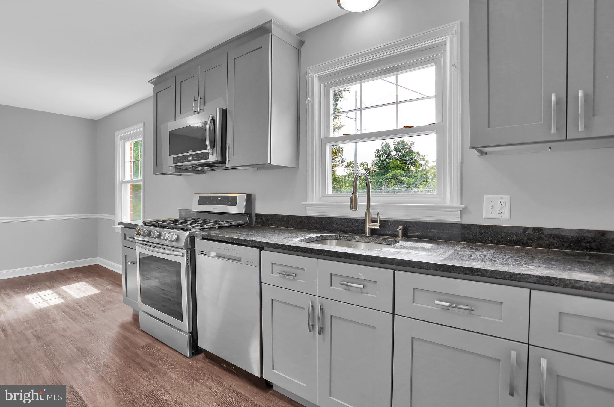 392 Waters Road York, PA 17403 - Photo 14 of 43 a kitchen with granite countertop white cabinets stainless steel appliances a window and a sink