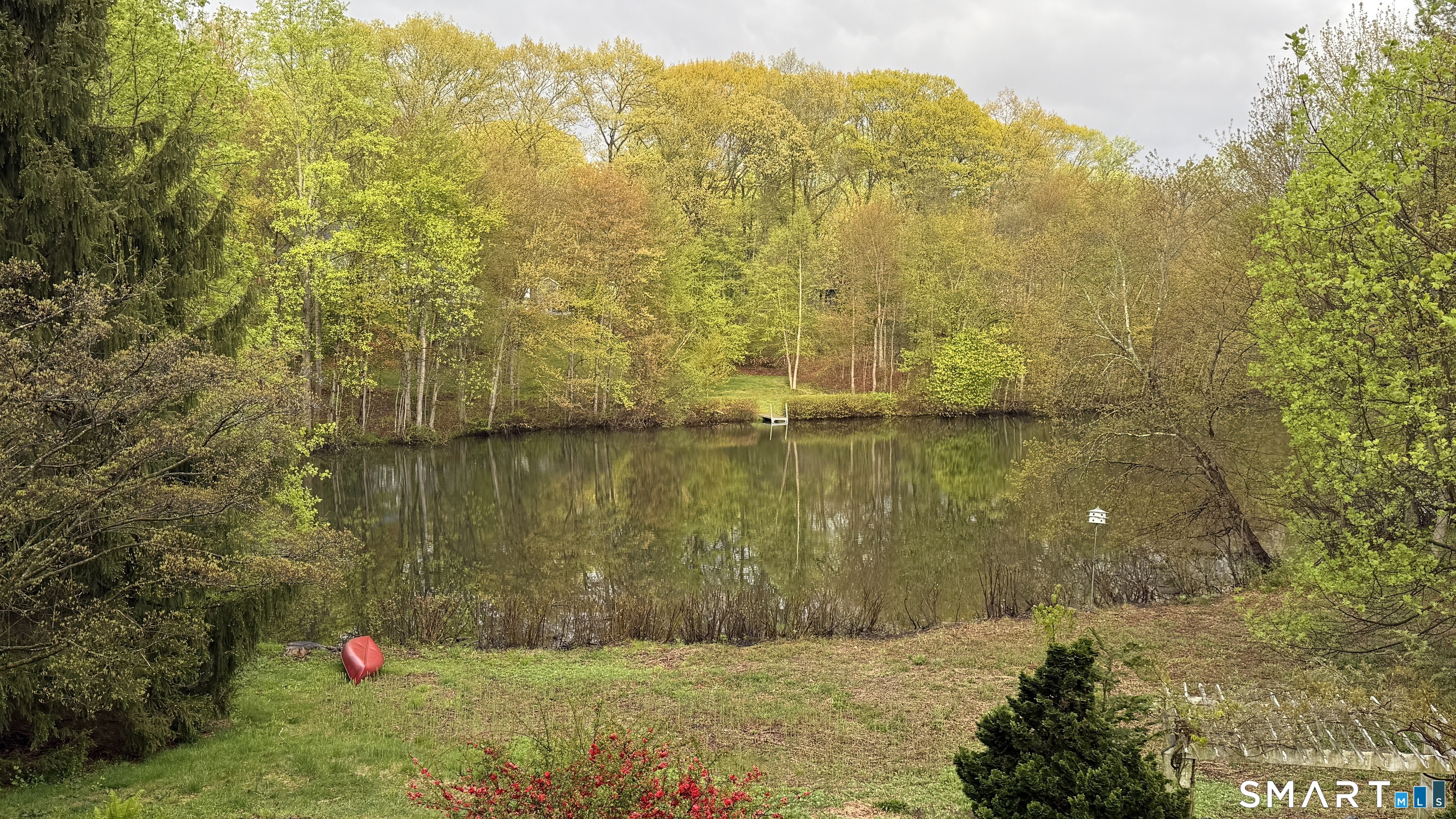 50 Turkey Meadow Road Trumbull, CT 06611 - Photo 35 of 40 Spring: Fresh blooms and budding trees bring new life to the lakefront. Gentle breezes ripple across the water as vibrant greenery returns, offering a refreshing and rejuvenating outdoor escape.
