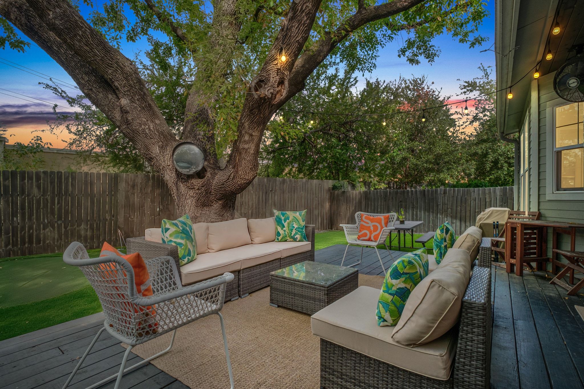 3302 Funston Street Austin, TX 78703 - Photo 4 of 36 Patio terrace at dusk with a wooden deck, outdoor lounge area, and a fenced backyard