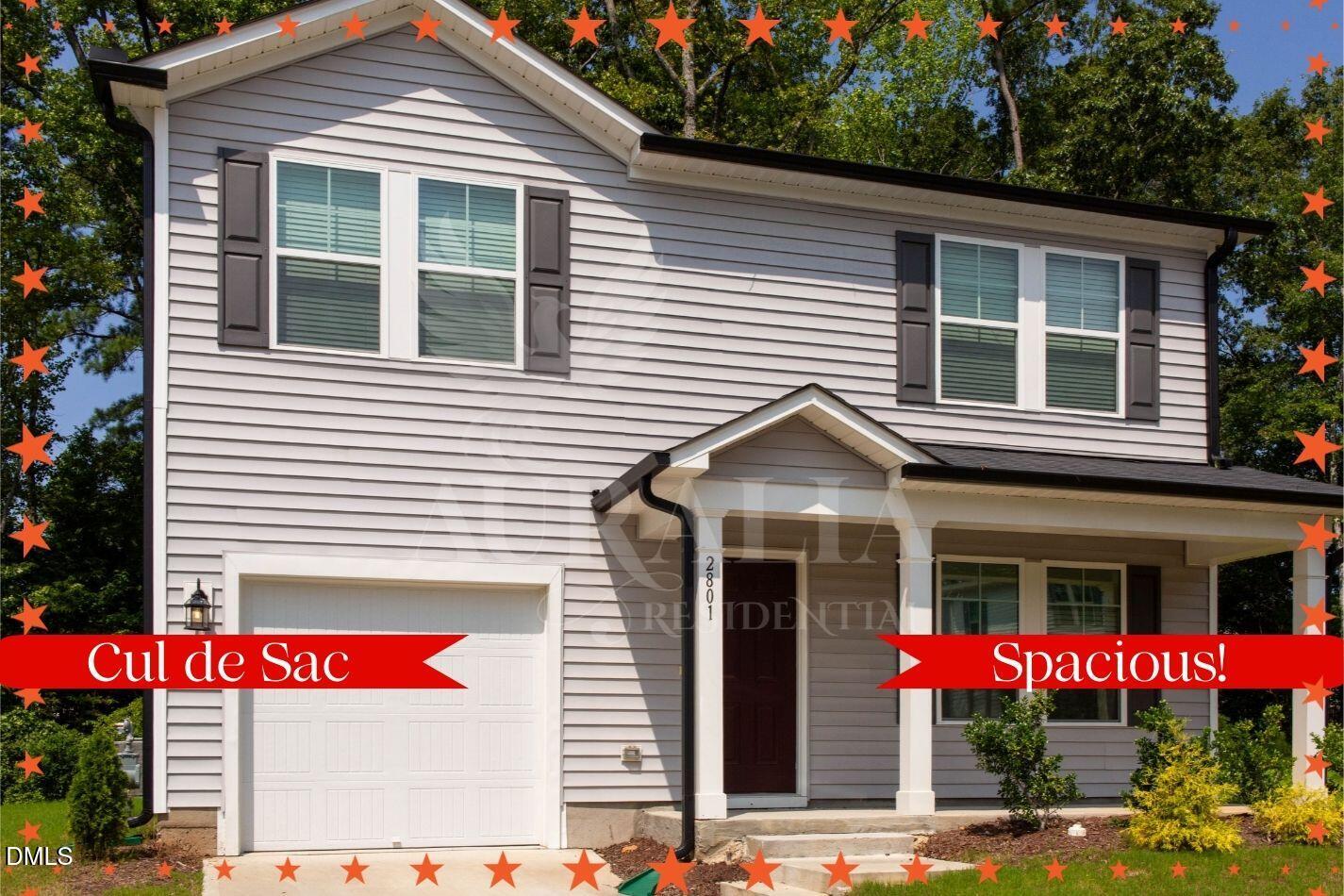 a front view of a house with a yard and potted plants