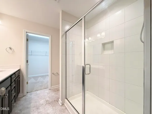 a bathroom with a granite countertop shower a mirror and a sink