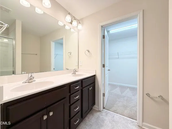 a bathroom with a double vanity sink mirror and shower