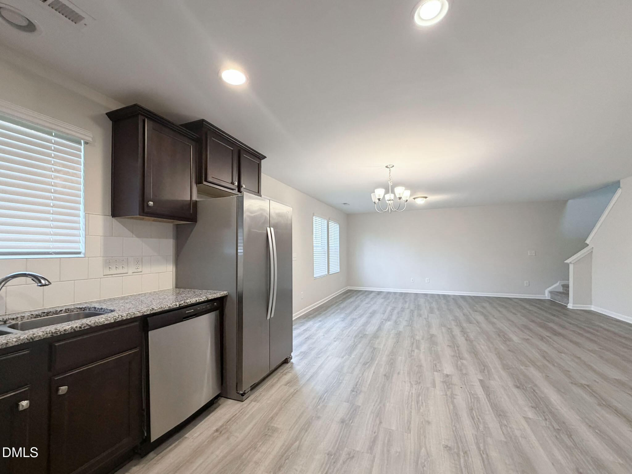 2801 Killian Court Raleigh, NC 27610 - Photo 7 of 26 a kitchen with granite countertop stainless steel appliances a sink cabinets and wooden floor