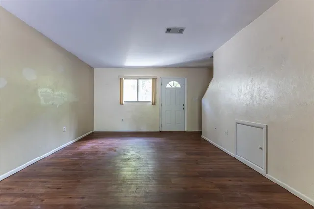 an empty room with wooden floor and mirror