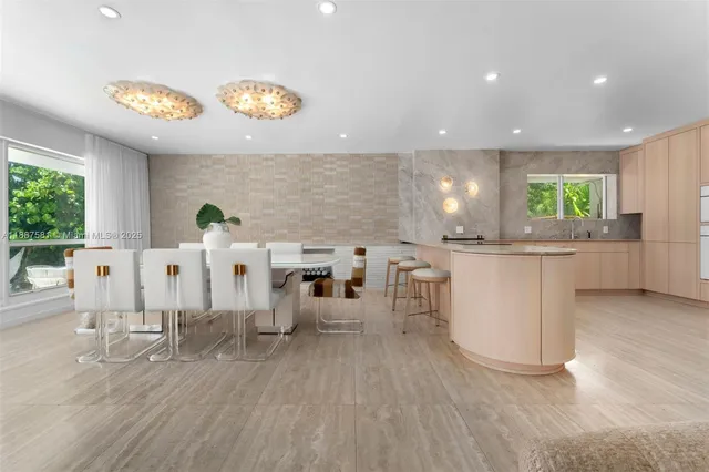 a large white kitchen with lots of counter space and chandelier