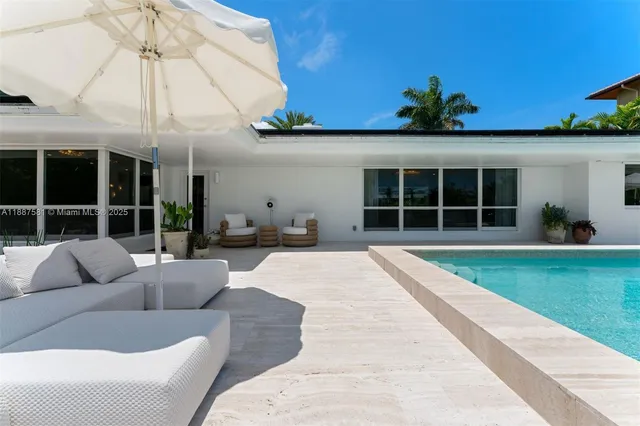 a front view of a house with swimming pool having outdoor seating