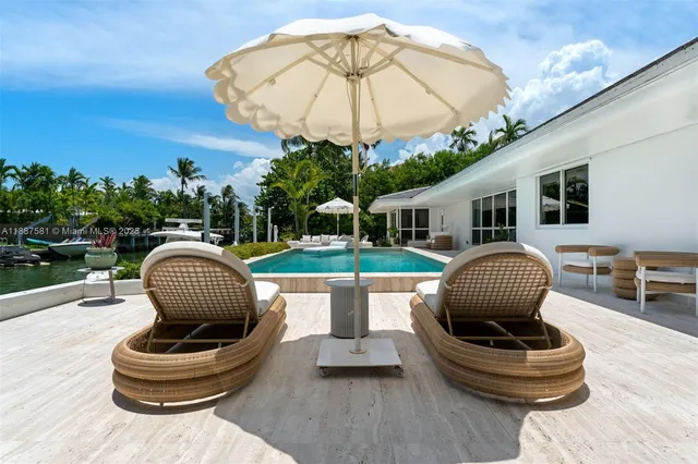 a view of a patio with a table and chairs under an umbrella