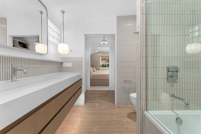 a bathroom with a sink a toilet and shower