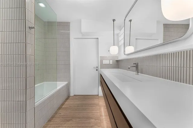 a bathroom with a sink a mirror and a shower