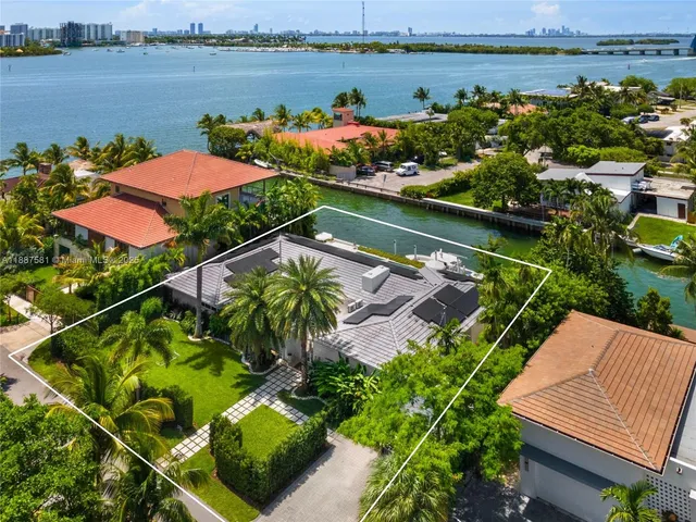 an aerial view of a house with swimming pool a yard and outdoor seating