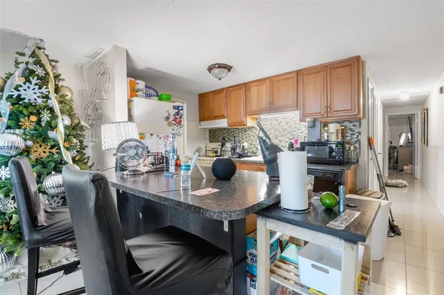 a living room with furniture a flat screen tv and a refrigerator