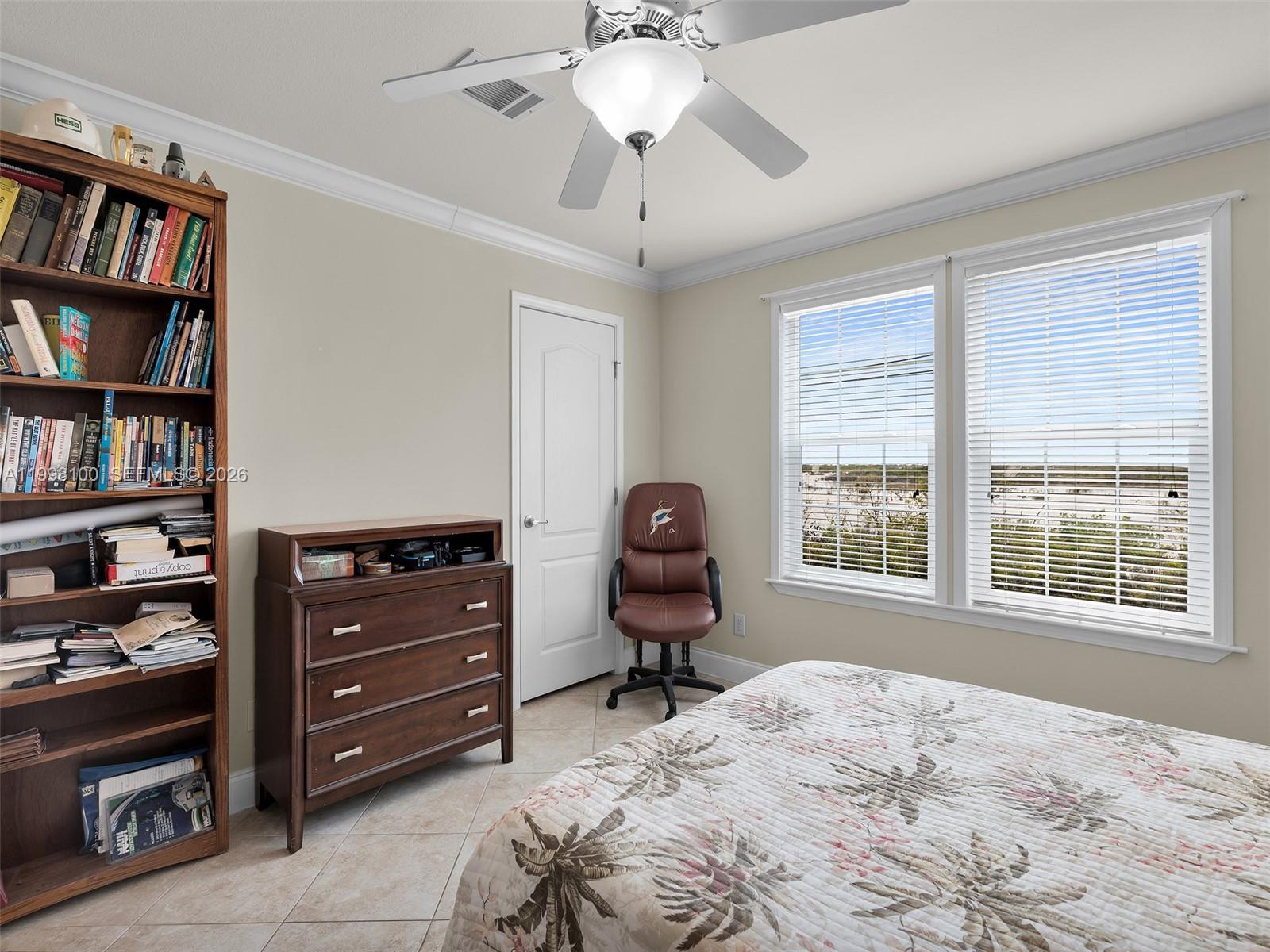 437 Pirates Road Summerland Key, FL 33042 - Photo 24 of 39 a bedroom with a bed and a book shelf