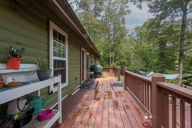 a view of a patio with table and chairs potted plants with wooden floor and fence