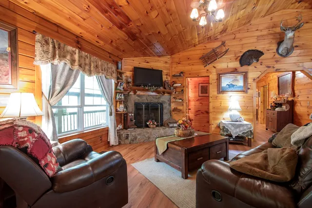 a outdoor living space with furniture a flat screen tv and a fireplace
