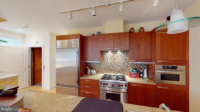 a very nice looking dining room with kitchen island stainless steel appliances a table and chairs
