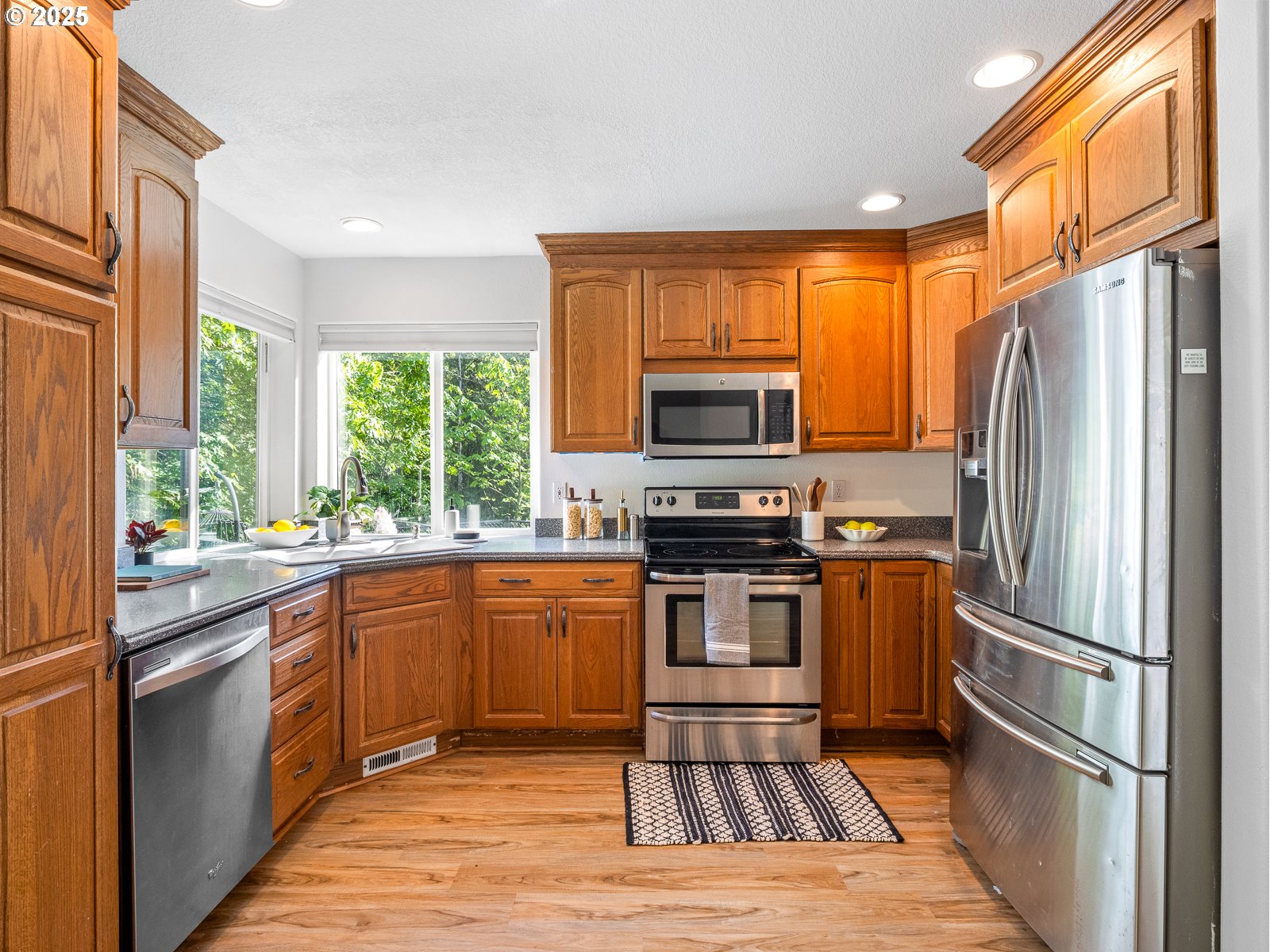 68 Southeast 47th Circle Gresham, OR 97080 - Photo 8 of 30 a kitchen with stainless steel appliances a stove a sink and a refrigerator