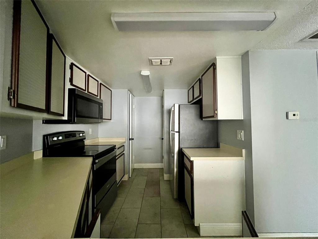 3964 Dream Oak Place, Unit 104 Tampa, FL 33613 - Photo 4 of 11 a kitchen with stainless steel appliances a refrigerator a stove top oven a sink and dishwasher